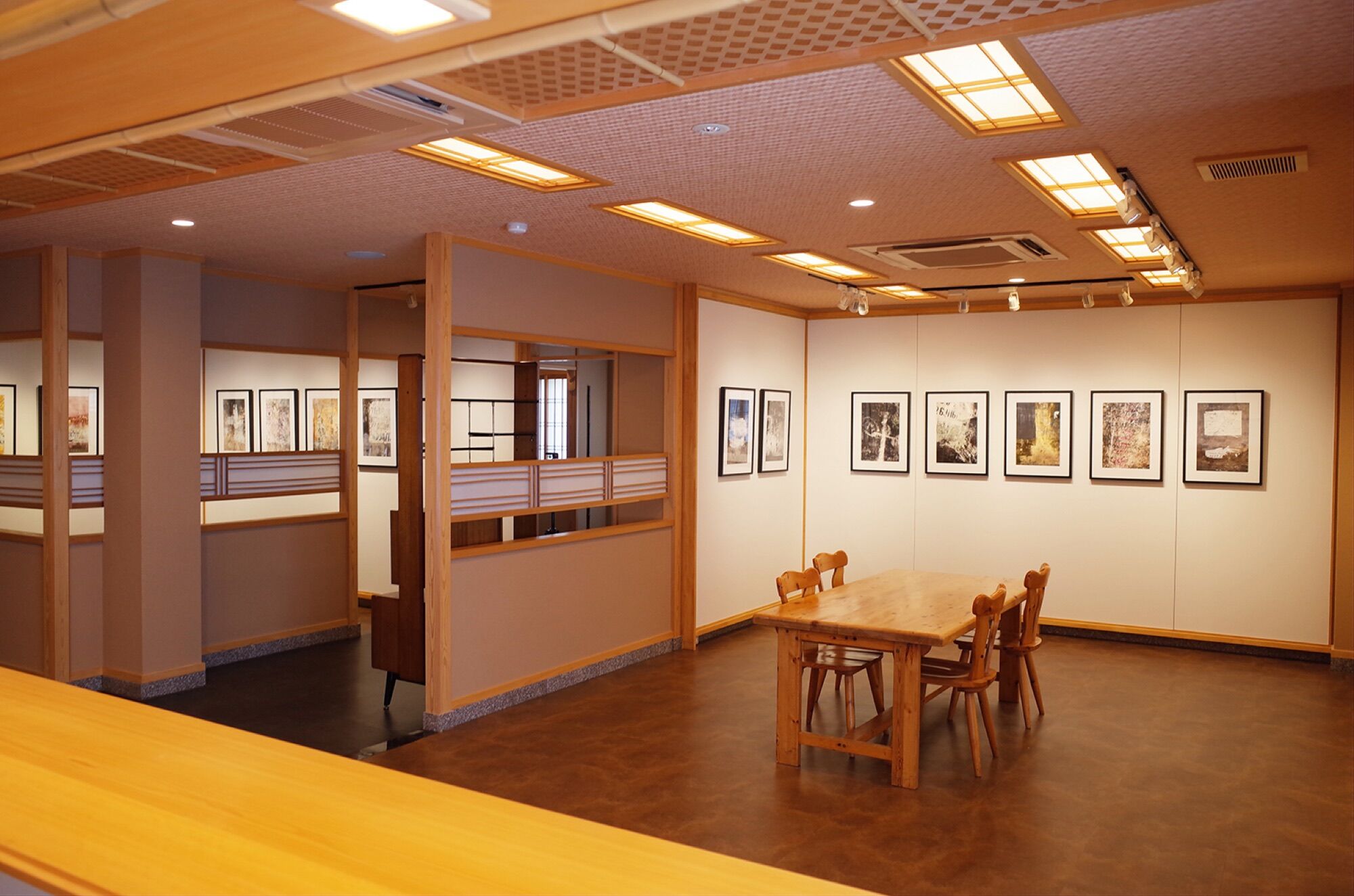 京都写真美術館の展示室。木の格子天井の下に作品が並ぶ